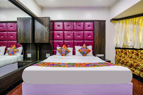 a bedroom with a large bed with a purple headboard at FabHotel King's Palace in Mumbai