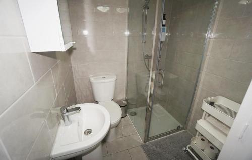 a bathroom with a shower and a toilet and a sink at Stylish Retreat By Aresti Hotels in London