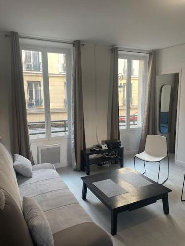 ein Wohnzimmer mit einem Sofa und einem Couchtisch in der Unterkunft Paris Puteaux Centre - Jean Jaurés in Puteaux