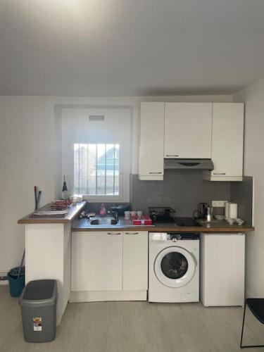 une cuisine avec des armoires blanches et une machine à laver dans l'établissement Paris Puteaux Centre - Jean Jaurés, à Puteaux