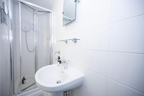 a white bathroom with a sink and a shower at The Little Marlowe - 1 Bed City Centre Cottage in Canterbury