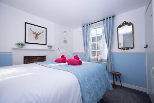 dos animales de peluche sentados en una cama en un dormitorio en The Little Marlowe - 1 Bed City Centre Cottage, en Canterbury