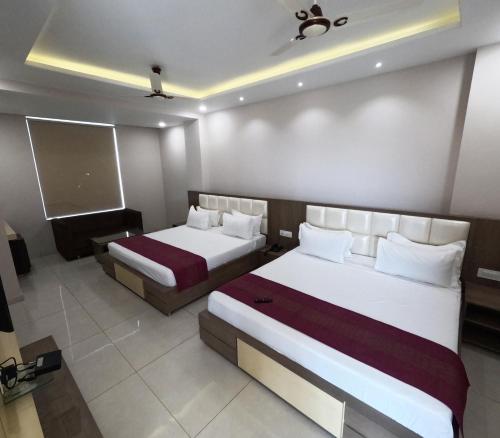 a hotel room with two beds and a tv at Hotel Annpurna Regency in Sīkar