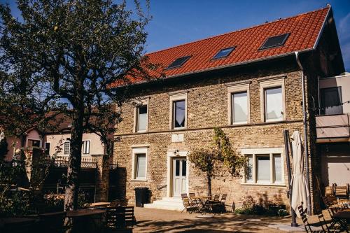 a large brick building with a red roof at GUT & GASTLICH Stallmann-Hiestand in Uelversheim