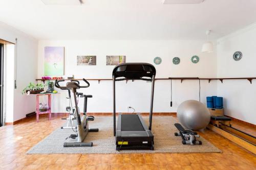 a room with a gym with a treadmill and a ball at Paradise Suites in Carcavelos