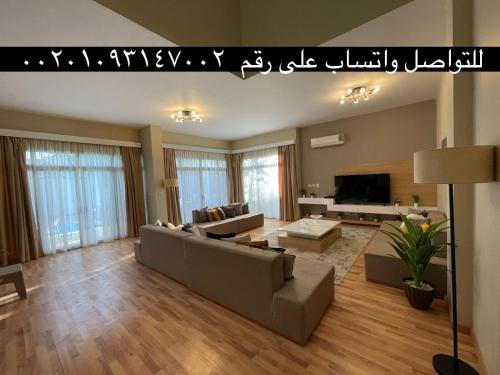 a living room with a couch and a tv at Villa paradise for rent in Elshikh zayed in Abū Rawwāsh