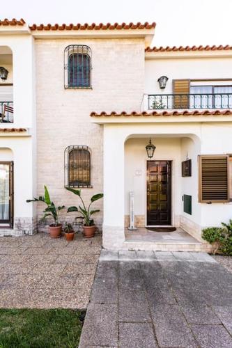 a white house with a door and a balcony at Paradise Suites in Carcavelos