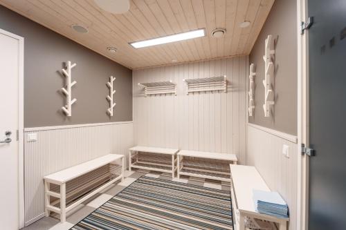 een kleedkamer met banken en een tapijt bij Hotelli Kotola in Kotka