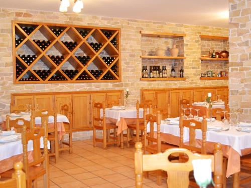 a restaurant with tables and chairs with wine bottles at Hotel Moregón in Cuacos de Yuste