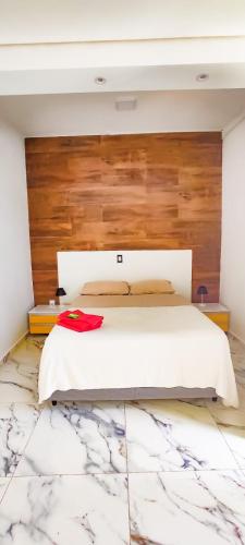 a bedroom with a white bed with a wooden headboard at Biomas Hotel in Brotas