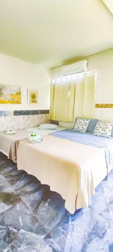 two beds in a room with a painting on the wall at Biomas Hotel in Brotas