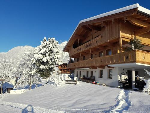 a building with snow on the ground in front of it at Topp Rossmoos in Alpbach