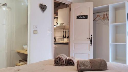 ein Zimmer mit einem Bett und einer Tür mit Handtüchern darauf in der Unterkunft Blois City - Le Petit Saint Jean in Blois