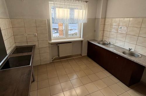 een badkamer met 2 wastafels en een raam bij Relaks Noclegi in Częstochowa