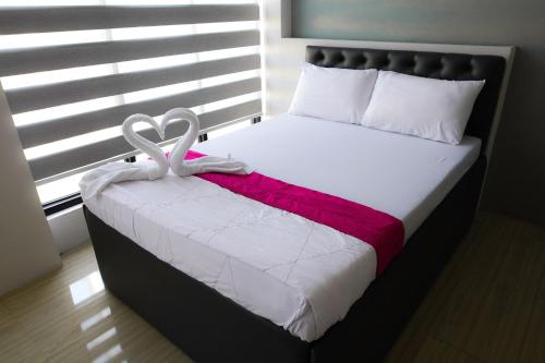 a bedroom with a bed with two white towels at OYO 1030 Ai Hotel in Manila