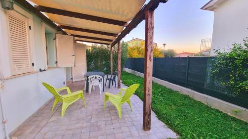 a patio with green chairs and a table and chairs at Appartamenti Mac, trilocali vicino al mare con posto auto in Marcelli
