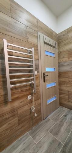 a bathroom with a wooden wall with a door at Apartment 35m2 in Karlovy Vary