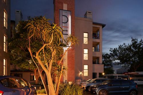 a building with cars parked in a parking lot at The Den Apartments by Raw Africa Collection in Stellenbosch