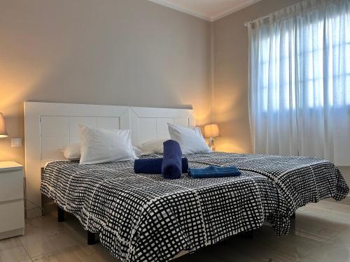 ein Schlafzimmer mit einem Bett mit einer schwarzen und weißen Decke in der Unterkunft Casa Aurora in Tías