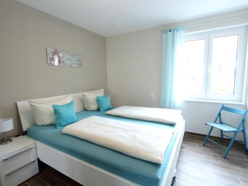 Schlafzimmer mit einem Bett in Blau und Weiß in der Unterkunft Residenz Blinkfüer Whg. 1 in Rerik