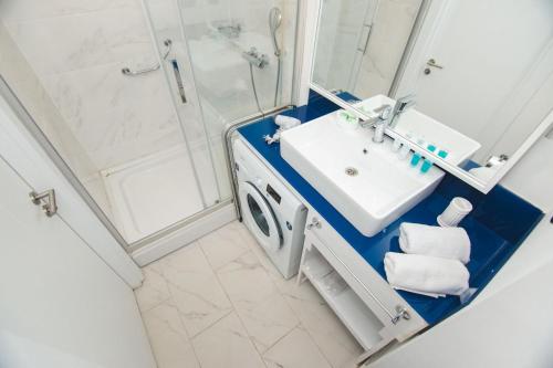 a bathroom with a washing machine and a sink at Orbi City Sea View in Batumi