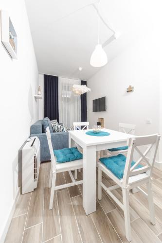 a kitchen and living room with a white table and chairs at La barca apartments in Becici