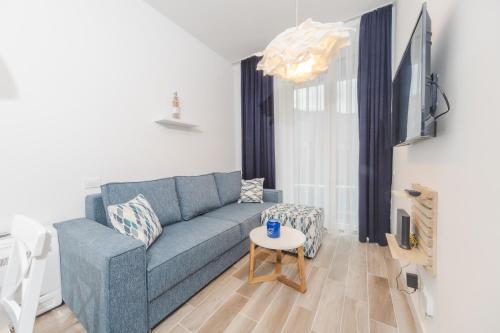 a living room with a blue couch and a table at La barca apartments in Becici
