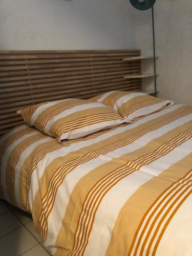 a large bed with two pillows on top of it at Appartement vue mer les pieds dans l'eau in Collioure