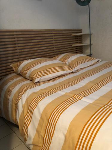 un grand lit avec deux oreillers dessus dans l'établissement Appartement vue mer les pieds dans l'eau, à Collioure