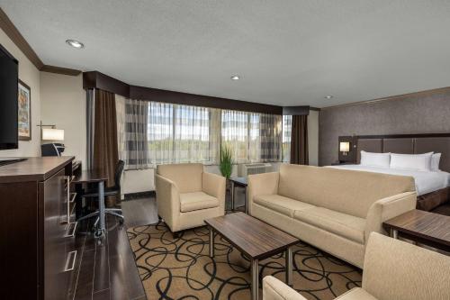 a hotel room with a bed and a living room at The Verve Boston Natick, Tapestry Collection by Hilton in Natick