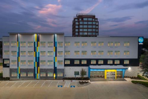 a large white building with a tall building in the background at Tru By Hilton North Richland Hills Dfw West in North Richland Hills