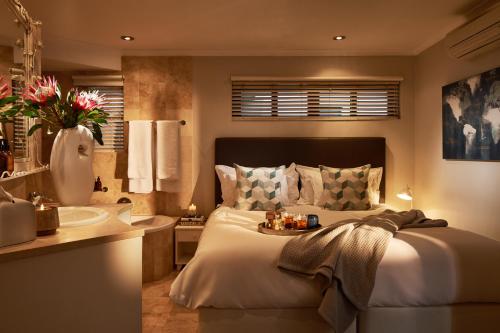 a bedroom with a large bed and a sink at 22 Eikehoff Apartment by Raw Africa Collection in Stellenbosch