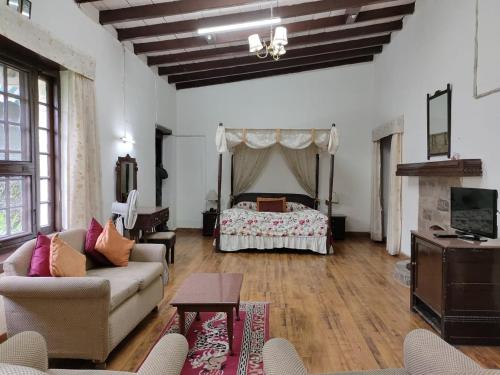 a living room with a couch and a bed at West View Hotel in Rānīkhet