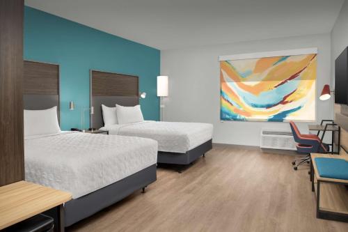 a hotel room with two beds and a table and chairs at Tru By Hilton North Richland Hills Dfw West in North Richland Hills