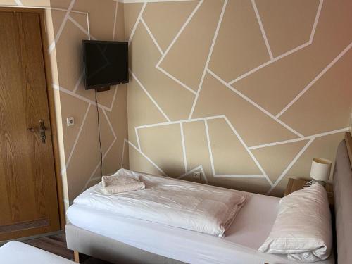 a room with a bed and a wall with a tv at Hotel zur Post limburg Bad camberg in Hünfelden