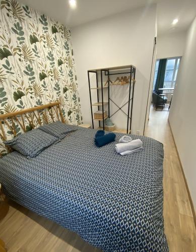 ein Schlafzimmer mit einem Bett in einem Zimmer mit einer Wand in der Unterkunft Joli appartement F2 plein centre Coutances in Coutances
