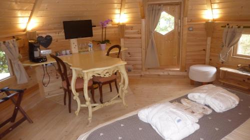 a room with a desk and a table in a cabin at Le Bassin du Tertre in Fronsac