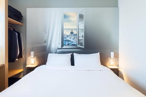 a bedroom with two beds and a window at B&B HOTEL Maurepas in Maurepas