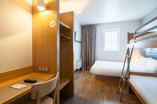 a hotel room with a desk and a bed and a bunk bed at B&B HOTEL Maurepas in Maurepas