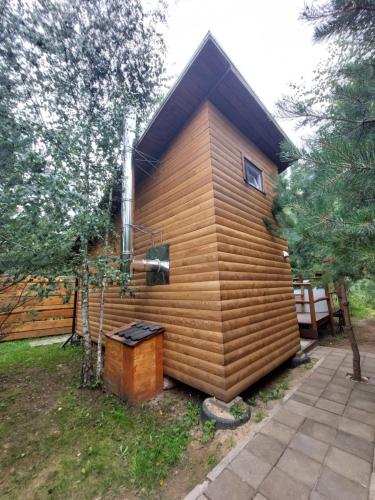 a small house with a wooden wall at Pasakų pirtelė in Vilnius