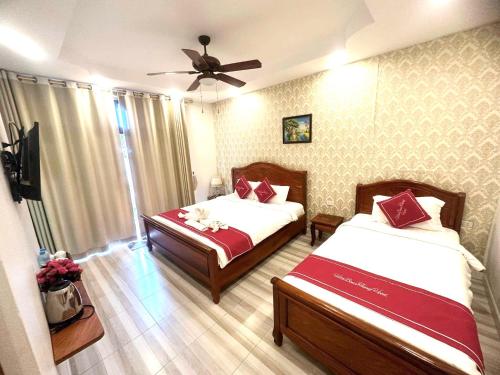 a bedroom with two beds and a ceiling fan at Luangprabang Villa bouathong Hotel in Luang Prabang