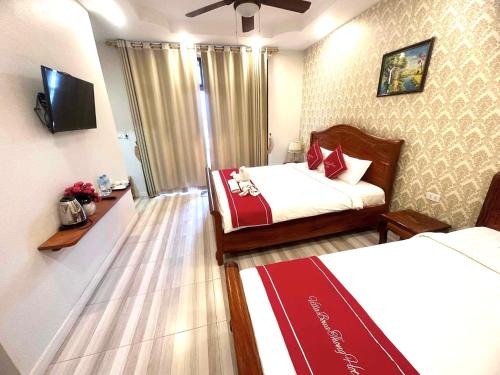 um quarto de hotel com duas camas e uma televisão em Luangprabang Villa bouathong Hotel em Luang Prabang