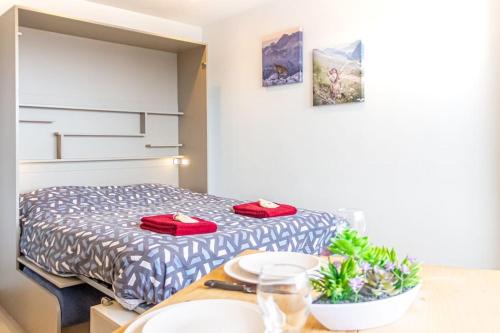 a bedroom with a bed with red pillows on it at ZenBNB / Azur / Proche Tram / Studio / Balcon Privé in Annemasse