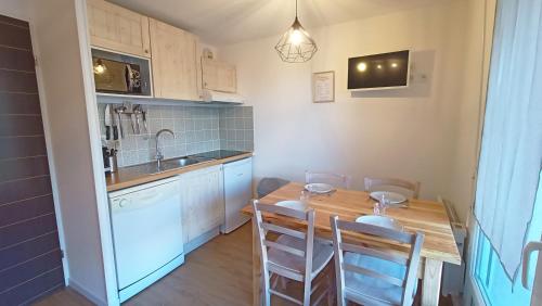 une petite cuisine avec une table et des chaises en bois dans l'établissement Studio Grand Balcon Montagne Ski et Randos, à Luz-Saint-Sauveur