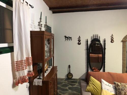 uma sala de estar com um sofá e um espelho em Quintinha dos Pombinhos em Montoito