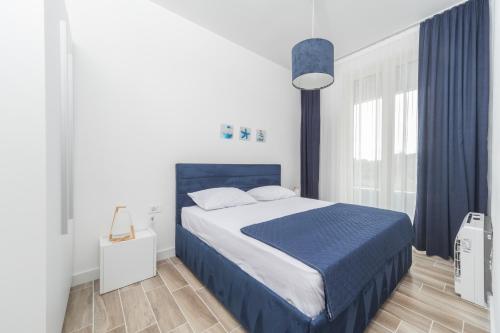 a bedroom with a large bed with a blue blanket at La barca apartments in Becici