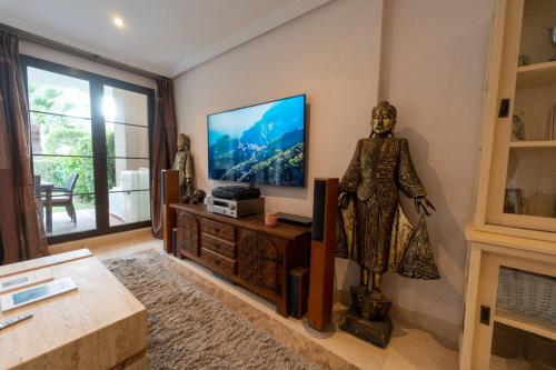 uma sala de estar com televisão e uma estátua em Marbella Luxury Boutique apartment in exclusive frontline golf development in a gated community with all facilities in walking distance em Benahavís