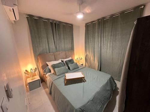 a bedroom with a bed with a table on it at L’écrin de Jade in Rémire-Camp