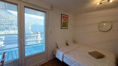 une chambre avec un lit et une grande fenêtre dans l'établissement Studio Grand Balcon Montagne Ski et Randos, à Luz-Saint-Sauveur