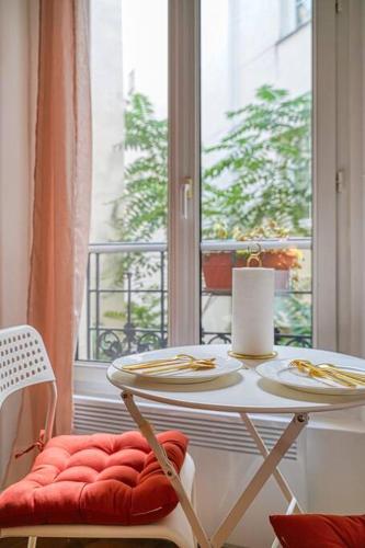 d'une table, de chaises et d'une fenêtre. dans l'établissement Charming appartment Paris Montmartre, à Paris